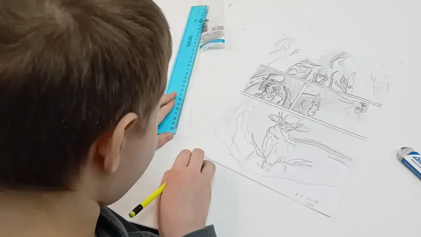 Un bambino impegnato a disegnare un fumetto