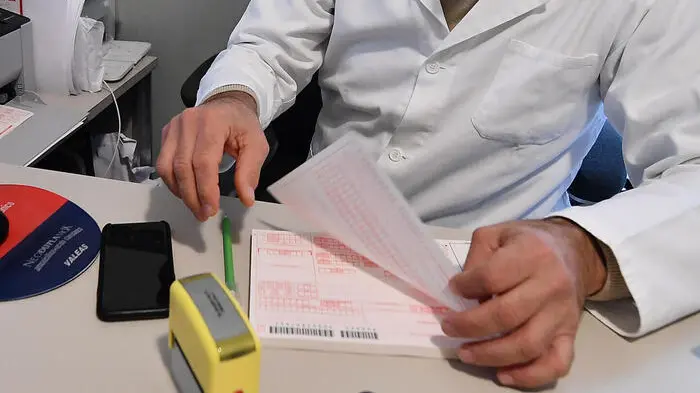 Un medico di base compila una ricetta. Foto Ansa