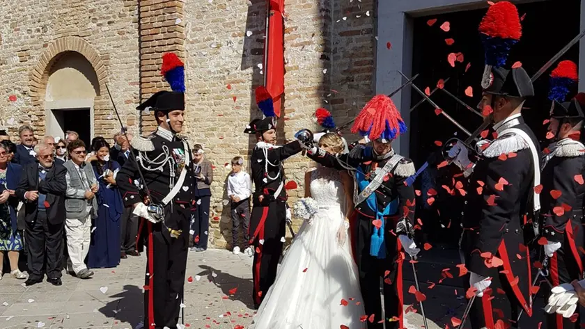 Una coppia di sposi novelli ricevono i saluti militari durante la loro cerimonia nuziale a Grado