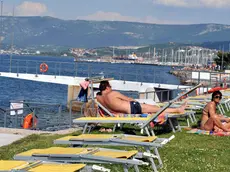 Bagnanti in relax al sole all’interno dello stabilimento di Porto San Rocco in una passata stagione. Foto Francesco Bruni