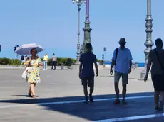 Una turista si ripara dal sole sotto un ombrellino