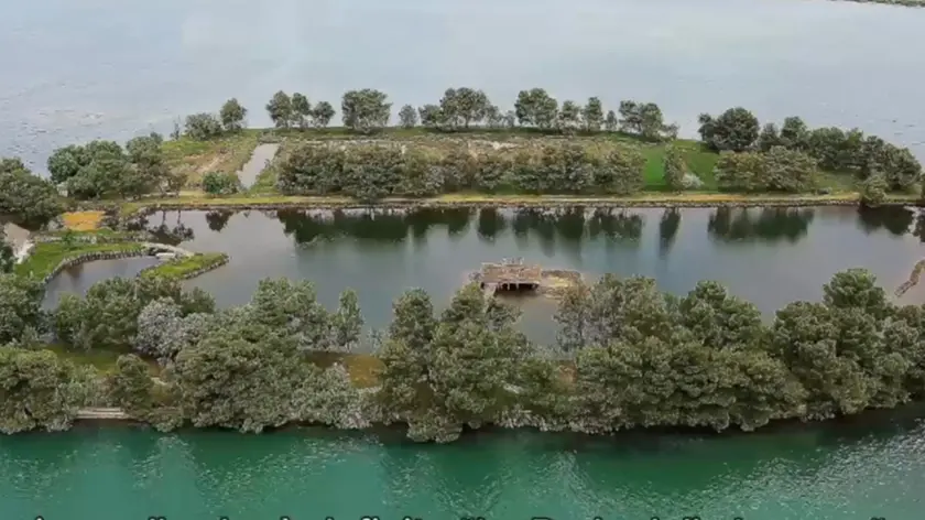 Una veduta aerea dell’area dell’Isola Orbi, o dei Orbi, e un dettaglio in prossimità di uno dei casoni: la procedura di vendita è in capo all’agenzia Oliva & Partners di Trieste
