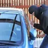 Un ladro guarda all’interno di un’auto parcheggiata ARCHIVIO
