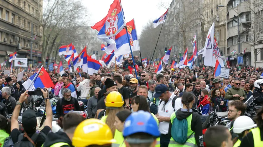 Alcuni manifestanti con le bandiere a Belgrado. Foto EPA