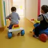 Due bambini mentre giocano divertiti all’interno di un asilo nido