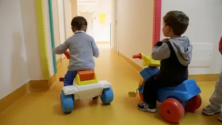 Due bambini mentre giocano divertiti all’interno di un asilo nido