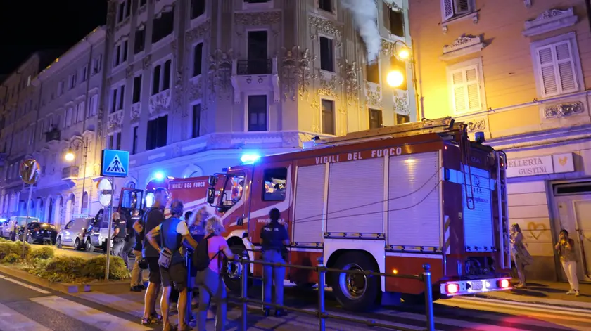Soccorritori e residenti davanti alla palazzina andata a fuoco