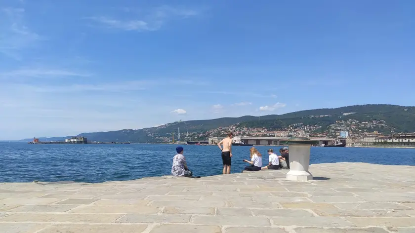 Un giovane turista sul molo Audace subito dopo il tuffo rinfrescante di martedì pomeriggio
