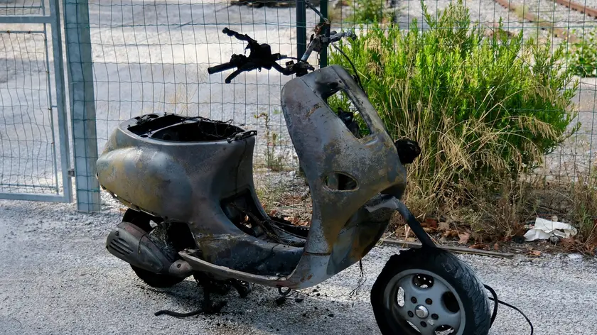 Il motorino distrutto dalle fiamme (Foto Silvano)