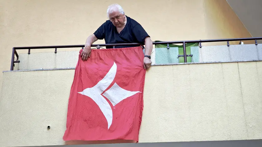 Il tifoso Dario Babuder espone il vessillo alabardato dell’era Deriù