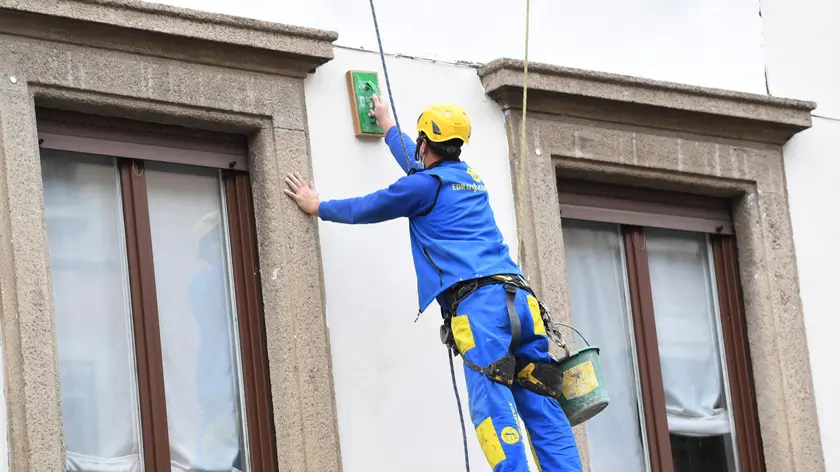 Operai acrobati al lavoro su un facciata di un palazzo a Milano, 1 dicembre 2021.