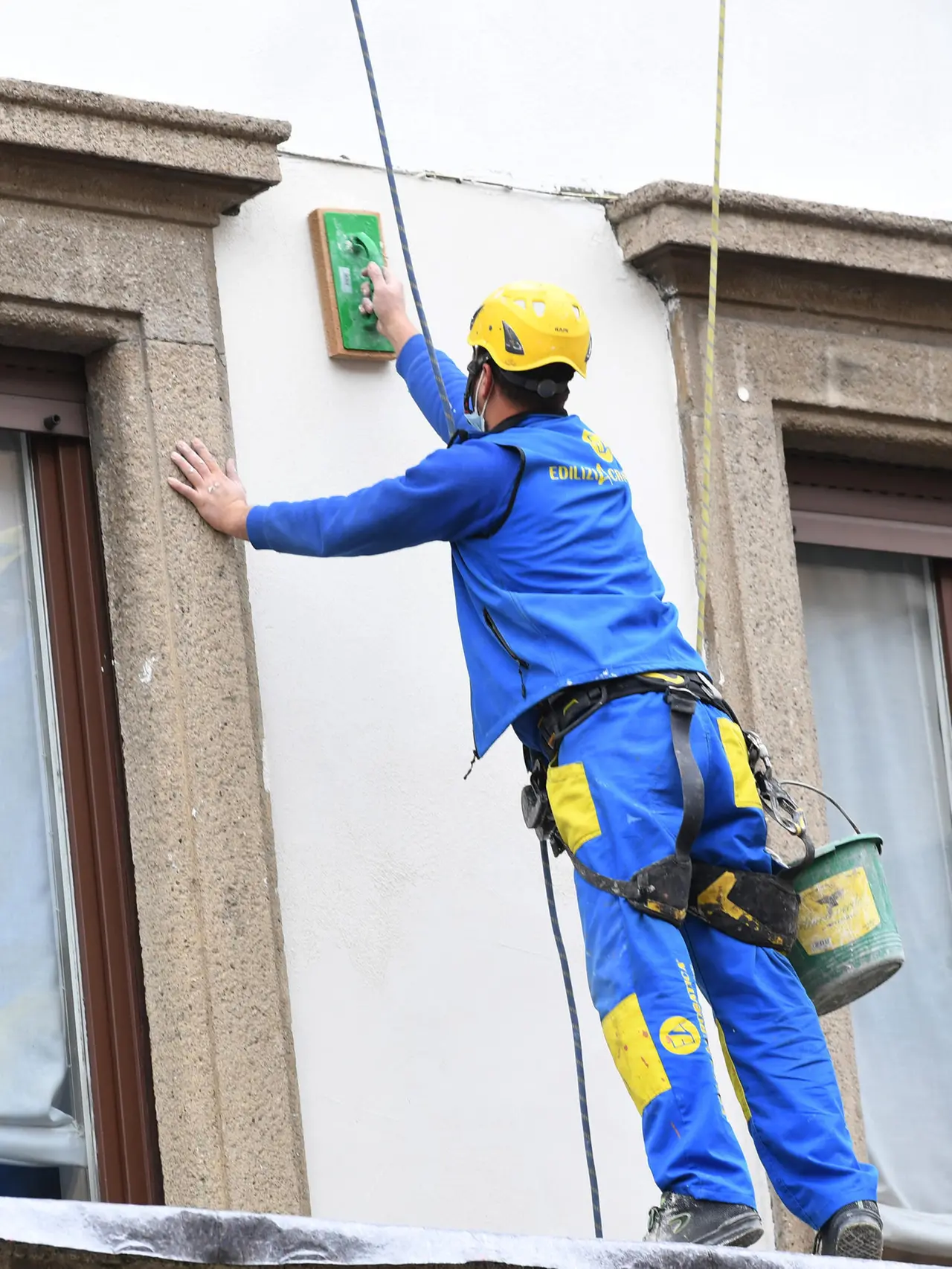 Operai acrobati al lavoro su un facciata di un palazzo a Milano, 1 dicembre 2021.