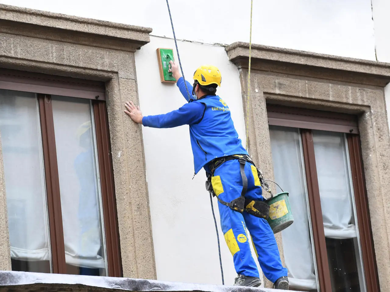 Operai acrobati al lavoro su un facciata di un palazzo a Milano, 1 dicembre 2021.