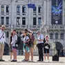Turisti con una guida in piazza Unità d’Italia dove il 14 agosto si svolgerà lo spettacolo con i droni Foto Andrea Lasorte