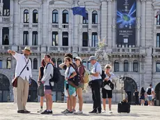 Turisti con una guida in piazza Unità d’Italia dove il 14 agosto si svolgerà lo spettacolo con i droni Foto Andrea Lasorte