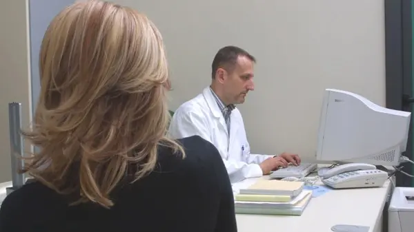 Un medico di base compila una prescrizione dopo una visita