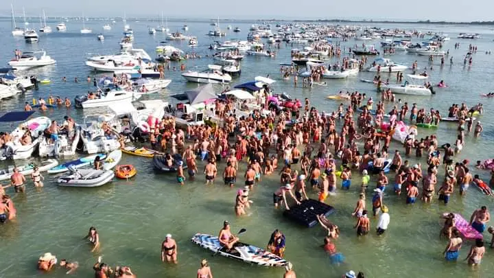 Immagini di edizioni passate del tradizionale raduno ferragostano ai caregoni, le tre vecchie strutture in cemento simili a grandi sedie di fronte al Lido di Staranzano e ben visibili anche da Marina Julia. Come ogni anno alla vigilia dell’appuntamento si rinnovano gli inviti al buon senso degli operatori della Riserva