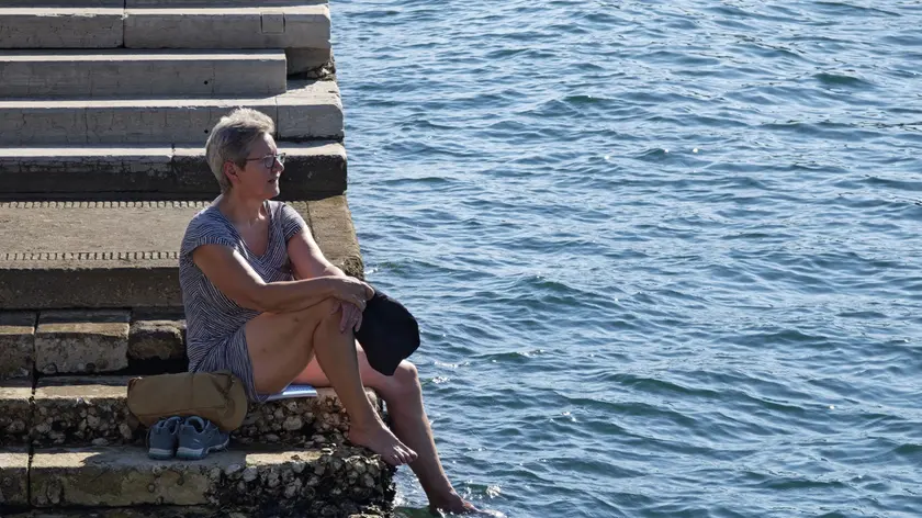 Una donna cerca refrigerio a Trieste (Foto Lasorte)