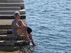 Una donna cerca refrigerio a Trieste (Foto Lasorte)