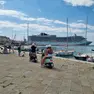 La famiglia in Vespa sulle Rive; turisti coni piedi nell’acqua alla Scala reale e in costume Foto Lasorte
