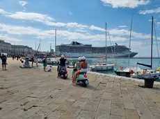 La famiglia in Vespa sulle Rive; turisti coni piedi nell’acqua alla Scala reale e in costume Foto Lasorte