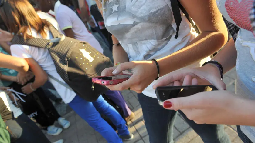 Ragazzi con il telefonino in una foto di archivio