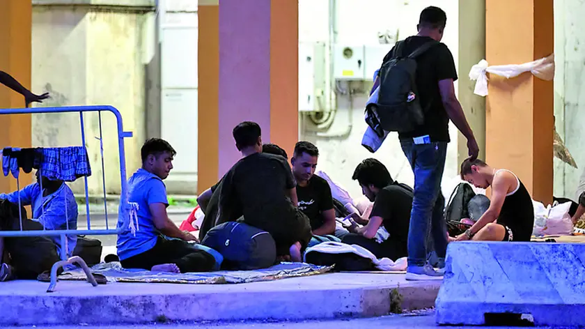Un gruppo di migranti accampati in Largo Santos. La Questura ha annunciato l’imminente stop ai bivacchi notturni nell’area foto massimo silvano