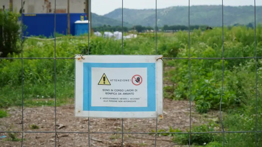 «Sono in corso lavori di bonifica amianto». Così recita un cartello in aeroporto e, sullo sfondo, si intravvedono i sacchi bianchi dove è stato riposto il materiale da rimuovere (Foto Marega).