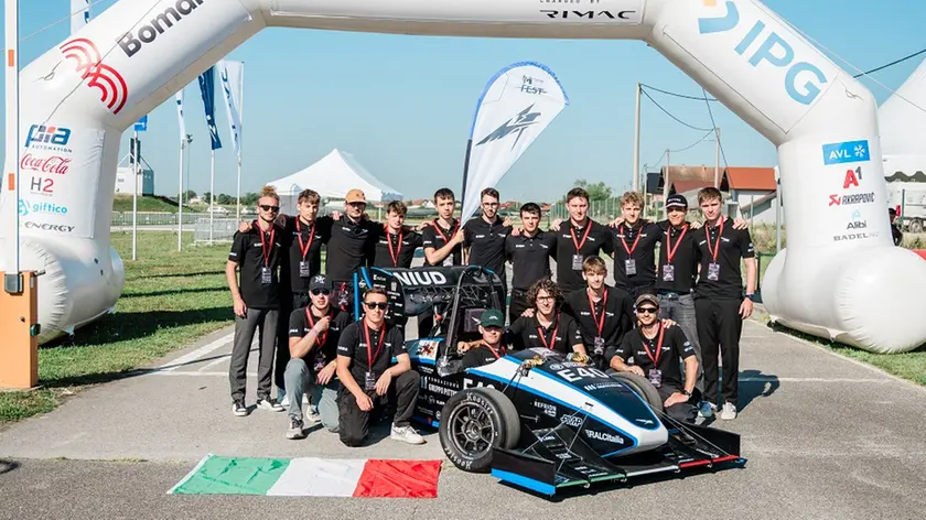 Foto di gruppo per l'Uniud E-Racing team con la monoposto elettrica