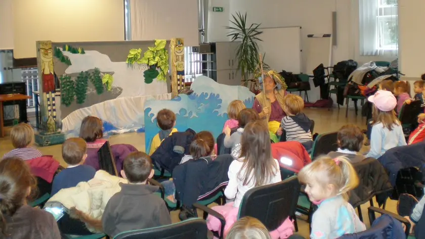 Un gruppo di bambini assiste a una rappresentazione teatrale all’interno del Burlo Garofolo