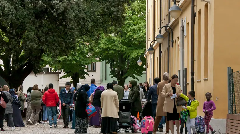 Bambini e genitori nel piazzale davanti all’ingresso della scuola primaria Duca d’Aosta