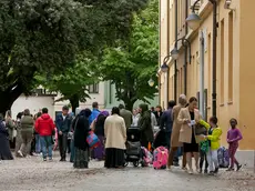 Bambini e genitori nel piazzale davanti all’ingresso della scuola primaria Duca d’Aosta