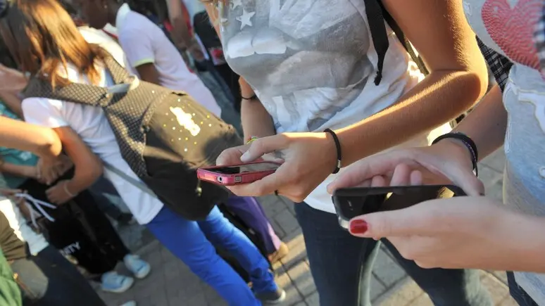 Giovani con lo smartphone: l’uso del cellulare a scuola è vietato