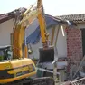 Una ruspa in azione su una costruzione abusiva. Foto archivio