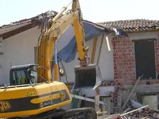 Una ruspa in azione su una costruzione abusiva. Foto archivio