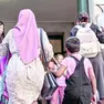 Una mamma musulmana che accompagna la propria figlia a scuola