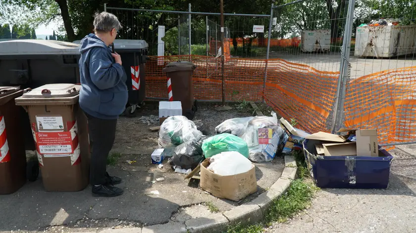 Sacchetti e scatoloni pieni di rifiuti abbandonati fuori dai cassonetti nella zona di Lucinico