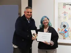 Il vicedirettore del gruppo Nem con delega al Piccolo Fabrizio Brancoli consegna il premio "Il Piccolo" all'autrice Desio