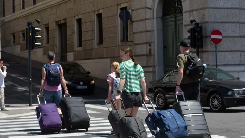 Una famiglia di turisti con i trolley in centro a Trieste Foto Bruni