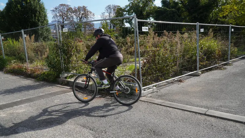 Detriti dopo la demolizione dell’ex prigione e ciclisti in movimento