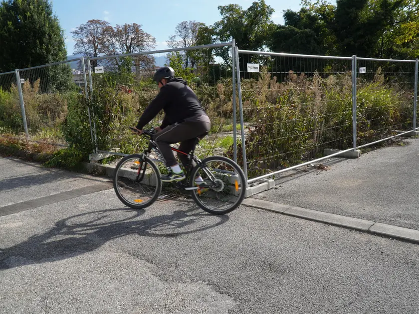 Detriti dopo la demolizione dell’ex prigione e ciclisti in movimento