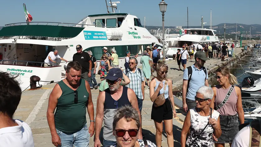 Turisti scendono a una fermata della linea marittima Delfino Verde