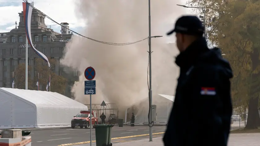 Uno dei tendoni in fiamme davanti al parlamento serbo. Foto Epa