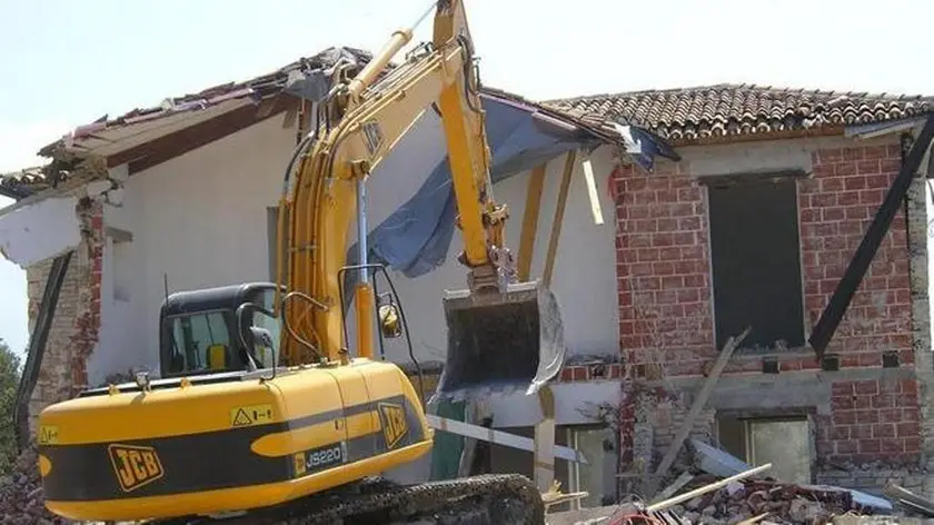 Una ruspa in azione su una casa abusiva archivio