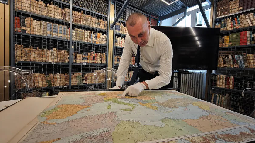 Il preside del Nautico Francesco Fazari nella biblioteca della scuola mostra Trieste su una mappa del secondo dopoguerra (Lasorte)