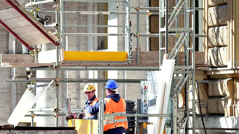 Operai al lavoro in un cantiere allestito per la ristrutturazione di un condominio