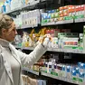 Una farmacista al lavoro tra scaffali pieni di medicinali e integratori (foto Silvano)