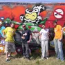 Alcuni componenti del gruppo Scimmie in gabbia davanti a murales colorati e a un concerto rap
