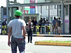 Operai di fronte ai cancelli dello stabilimento Fincantieri di Panzano