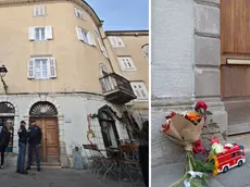 A sinistra gli agenti davanti allo stabile di piazza Marconi, dove si è consumata la tragedia. Foto Lasorte. A destra fiori e un mezzo dei pompieri sulla porta